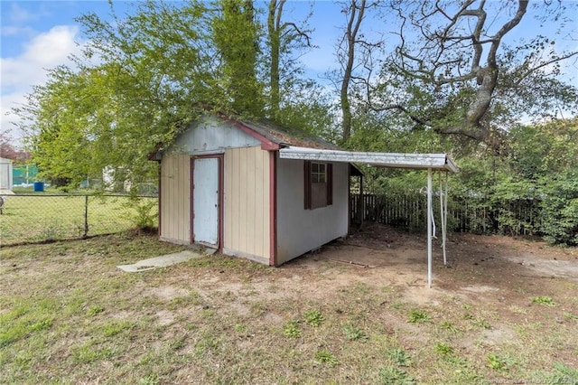 view of shed featuring a carport and fence