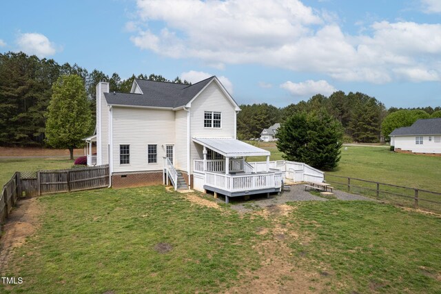rear view of property with a fenced backyard, a lawn, a chimney, and a wooden deck