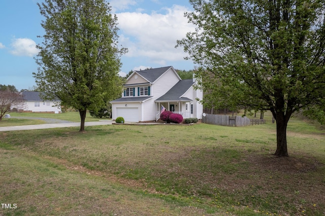 traditional home with driveway, an attached garage, fence, and a front lawn