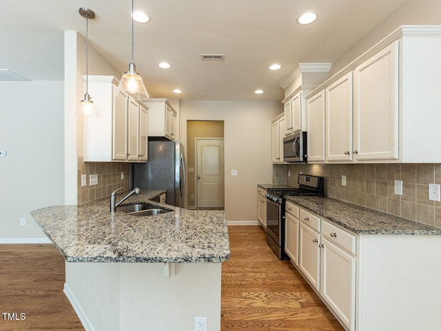 112 Churment Ct, Durham, NC 27703 - kitchen featuring stainless steel appliances, a peninsula, light wood-type flooring, white cabinetry, and recessed lighting