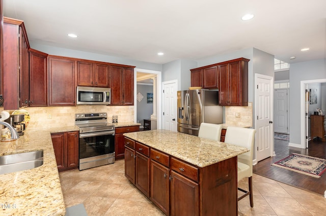 6020 Jones Farm Rd, Wake Forest, NC 27587 - kitchen featuring stainless steel appliances, a sink, backsplash, a center island, and light stone countertops