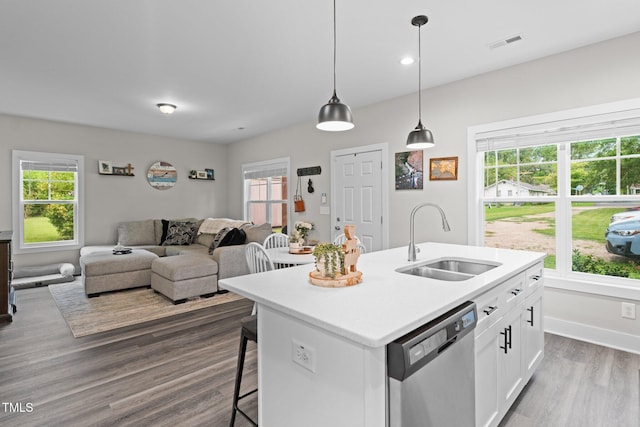 kitchen with white cabinetry, a kitchen bar, dark wood-type flooring, a sink, and dishwasher