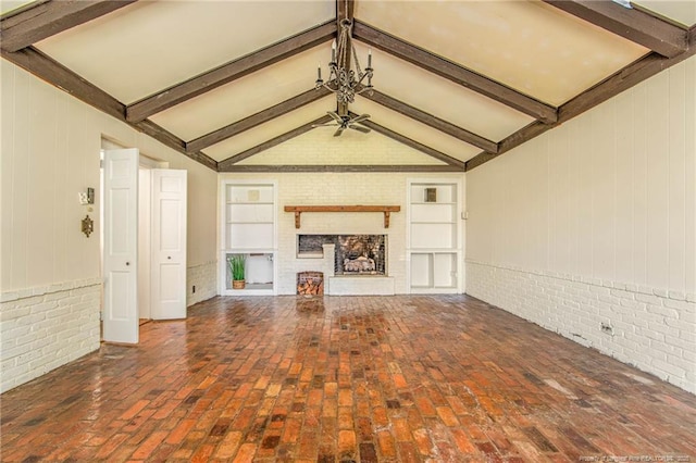 unfurnished living room featuring a ceiling fan, brick wall, built in features, and vaulted ceiling with beams