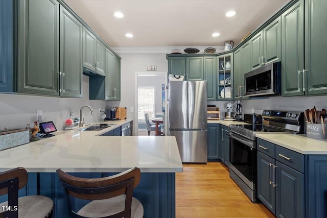 15 Longwood Dr, Youngsville, NC 27596 - kitchen with light countertops, stainless steel appliances, a breakfast bar, a sink, and a peninsula