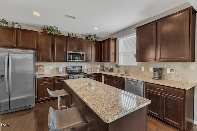 kitchen featuring dark wood-type flooring, visible vents, a sink, and stainless steel appliances
