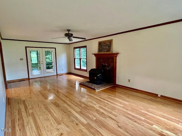 1401 Roy Averette Dr, Raleigh, NC 27603 - unfurnished living room with ornamental molding, light wood-style flooring, ceiling fan, a wood stove, and french doors