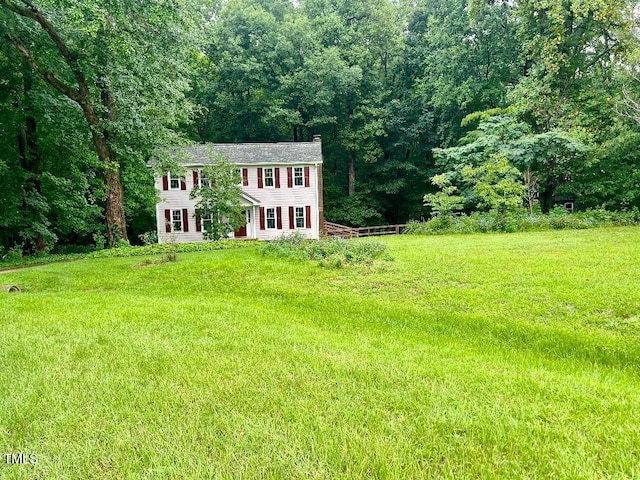 1401 Roy Averette Dr, Raleigh, NC 27603 - view of front of home with a chimney, an outdoor structure, a forest view, and a front lawn