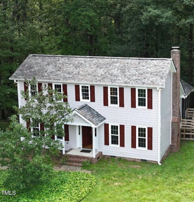 1401 Roy Averette Dr, Raleigh, NC 27603 - colonial-style house featuring a chimney, a front yard, and a view of trees