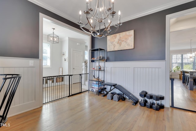 interior space featuring an inviting chandelier, wainscoting, and wood finished floors