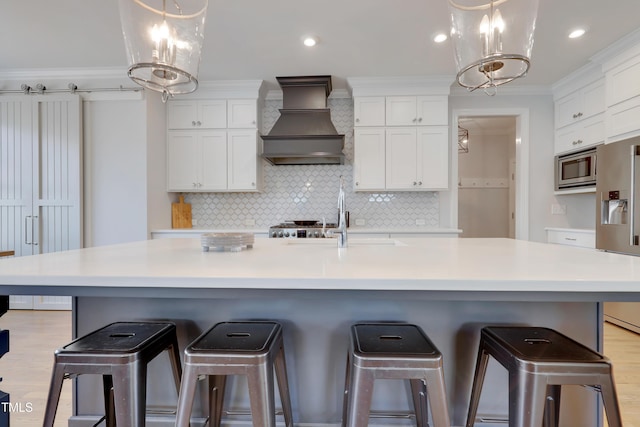 kitchen with white cabinets, stainless steel appliances, and custom range hood