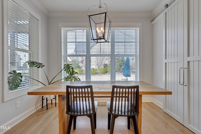 dining area with baseboards, light wood-style floors, a notable chandelier, and a healthy amount of sunlight