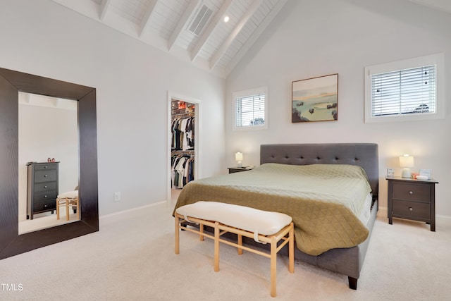 carpeted bedroom with baseboards, a spacious closet, beam ceiling, and a closet