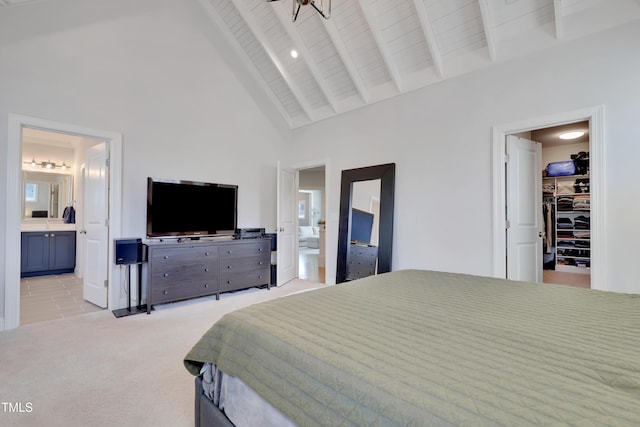 bedroom with light colored carpet, high vaulted ceiling, beamed ceiling, a spacious closet, and ensuite bathroom