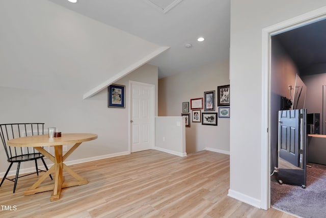 interior space with baseboards, recessed lighting, light wood finished floors, and vaulted ceiling
