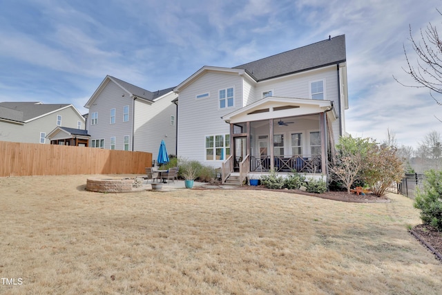 rear view of house with a lawn, ceiling fan, fence, and covered porch