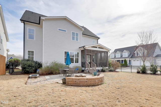 back of property with roof with shingles, an outdoor fire pit, a sunroom, a fenced backyard, and a patio