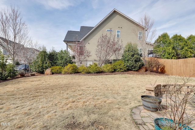 view of property exterior featuring a lawn and fence
