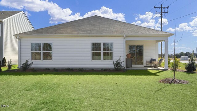 501 Ivory Ln, Goldsboro, NC 27534 - rear view of house featuring roof with shingles, a patio area, and a lawn