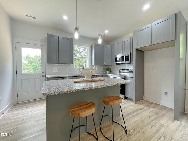 112 Remington Woods Dr, Wake Forest, NC 27587 - kitchen featuring stainless steel appliances, a center island, light wood-type flooring, gray cabinets, and recessed lighting