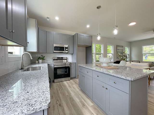 112 Remington Woods Dr, Wake Forest, NC 27587 - kitchen featuring appliances with stainless steel finishes, a sink, gray cabinets, light stone countertops, and recessed lighting