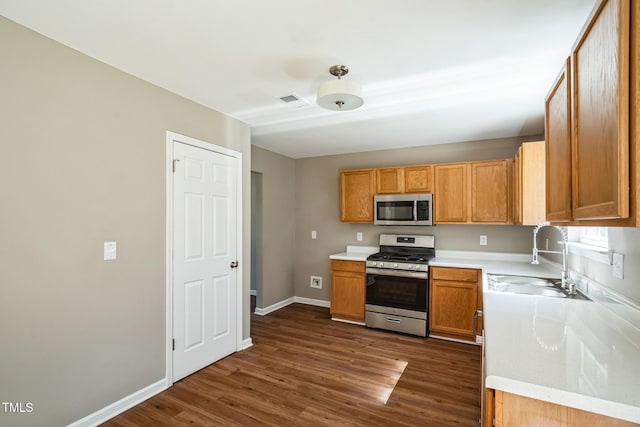 3316 Perkins Ridge Rd, Raleigh, NC 27610 - kitchen featuring stainless steel appliances, a sink, dark wood-style floors, light countertops, and baseboards