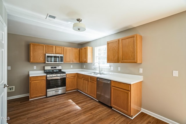 3316 Perkins Ridge Rd, Raleigh, NC 27610 - kitchen with stainless steel appliances, a sink, dark wood-style floors, baseboards, and light countertops