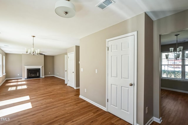 3316 Perkins Ridge Rd, Raleigh, NC 27610 - unfurnished living room featuring a chandelier, wood finished floors, baseboards, and a fireplace