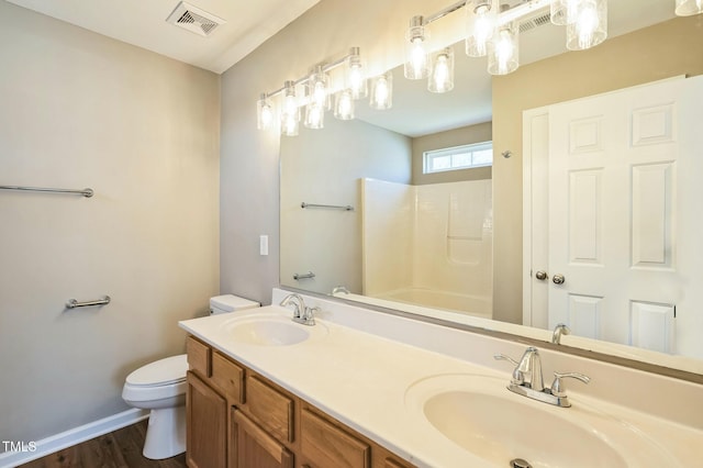 3316 Perkins Ridge Rd, Raleigh, NC 27610 - full bath featuring toilet, wood finished floors, double vanity, baseboards, and shower / tub combination
