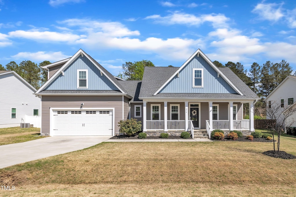 view of front of house with cooling unit, board and batten siding, driveway, a front yard, and a porch