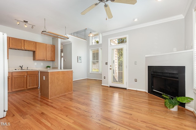 440 Heritage Village Ln, Apex, NC 27502 - kitchen featuring light countertops, crown molding, light wood-style flooring, ceiling fan, and brown cabinets