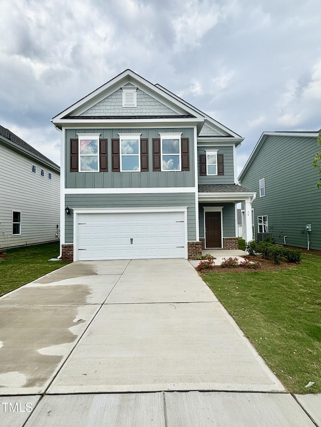 76 Commons Cir, Clayton, NC 27520 - view of front of home with driveway, a garage, brick siding, and a front yard