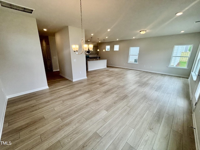 76 Commons Cir, Clayton, NC 27520 - unfurnished living room featuring a chandelier, recessed lighting, light wood-style flooring, and baseboards