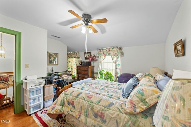 bedroom with lofted ceiling, visible vents, wood finished floors, and a ceiling fan