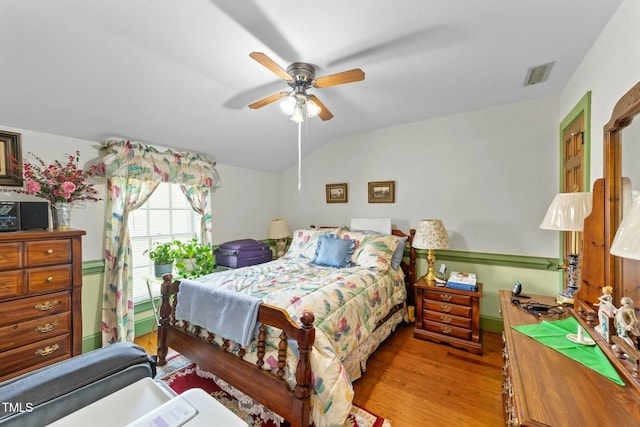 bedroom featuring lofted ceiling, visible vents, wood finished floors, and ceiling fan