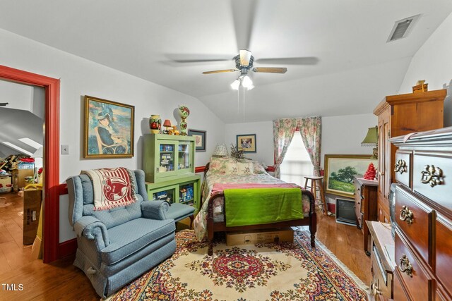 bedroom featuring visible vents, vaulted ceiling, and wood finished floors