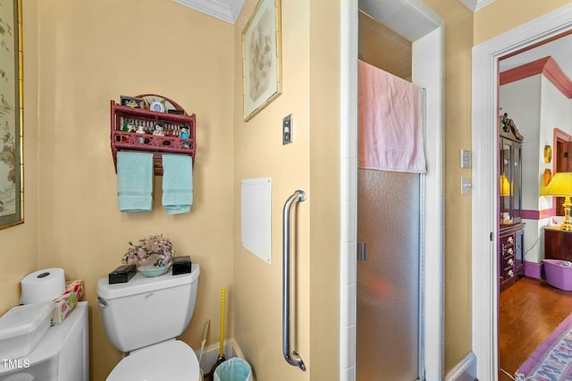 full bath featuring toilet, a stall shower, and crown molding