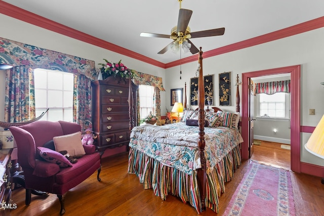 bedroom with crown molding, multiple windows, and wood finished floors