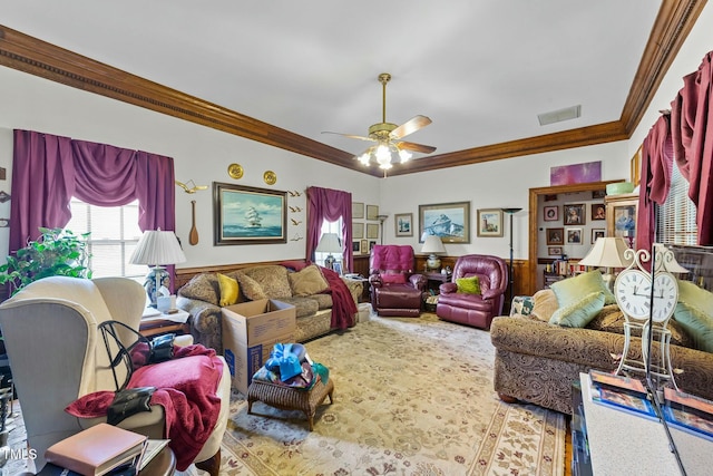 living area featuring crown molding, carpet floors, visible vents, a ceiling fan, and wainscoting