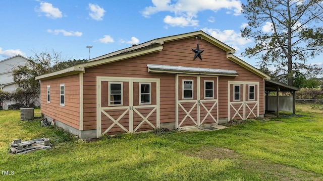 view of outdoor structure featuring an outbuilding, fence, and central AC