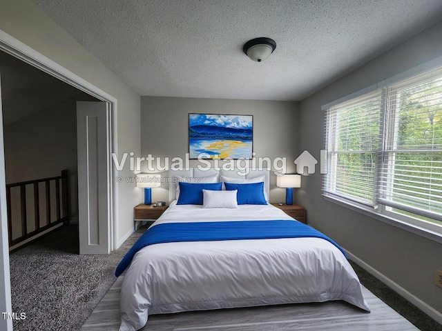 bedroom with baseboards and a textured ceiling