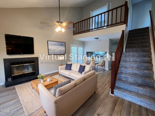 living room with baseboards, stairs, and a towering ceiling