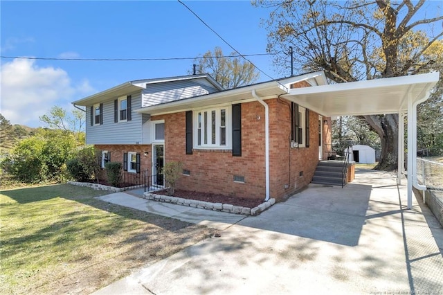 split level home with a front yard, concrete driveway, an attached carport, brick siding, and crawl space