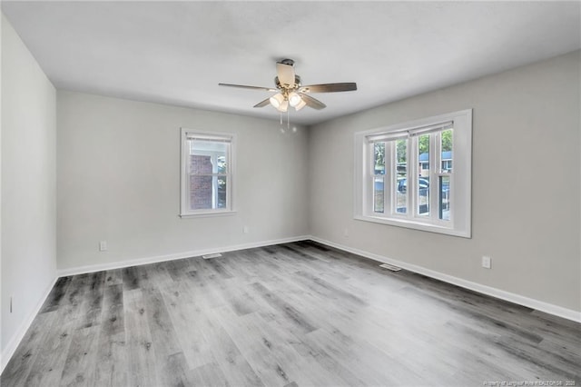 spare room with wood finished floors, baseboards, and ceiling fan