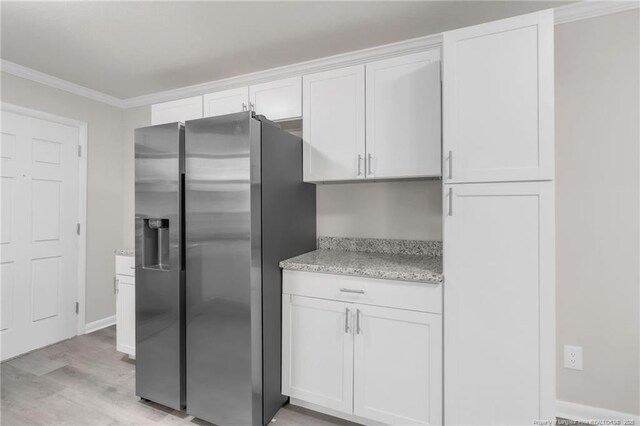kitchen with light wood-style flooring, ornamental molding, white cabinetry, light stone counters, and stainless steel fridge with ice dispenser