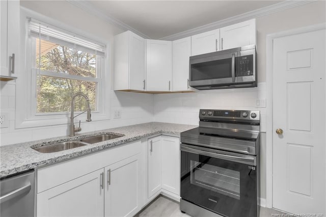 kitchen featuring ornamental molding, a sink, backsplash, and appliances with stainless steel finishes