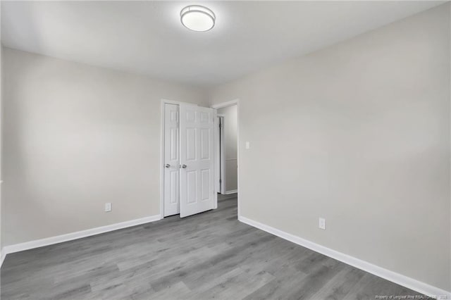 unfurnished room with baseboards and wood finished floors