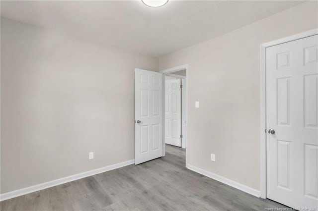 unfurnished bedroom with baseboards and wood finished floors