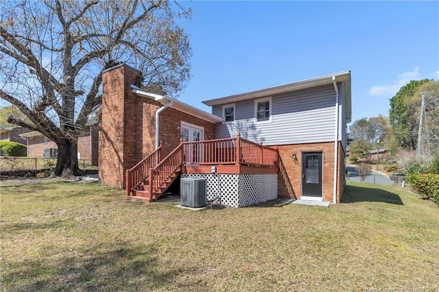rear view of property with central AC unit, brick siding, and a yard