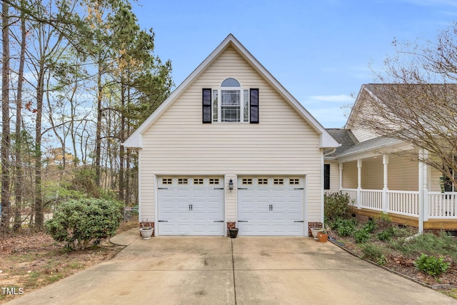 view of side of home with concrete driveway, covered porch, and a garage
