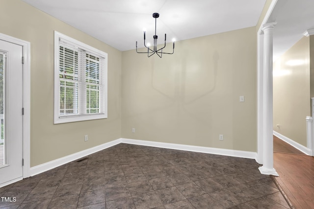 interior space featuring baseboards, ornate columns, and a notable chandelier